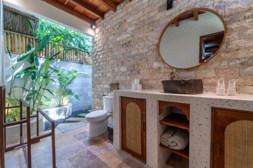 un baño con lavabo y espejo en La Villa Loca, en Gili Air