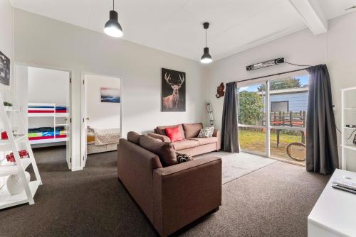 a living room with a couch and a bedroom at Riverside Haven - Turangi Holiday Home in Turangi