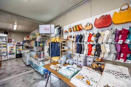 a store with a lot of bags and shoes on the wall at ねこ蔵の宿 飛騨 in Hida