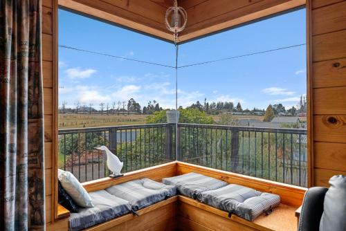 a room with a balcony with a large window at Riverside Haven - Turangi Holiday Home in Turangi