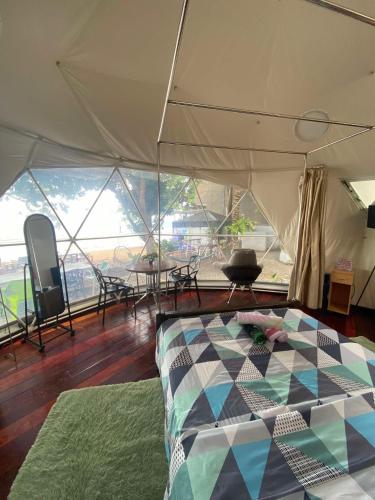 a tent with a bed and a table and chairs at Beach Glamping Dome Dauin Modern Style in Dauin
