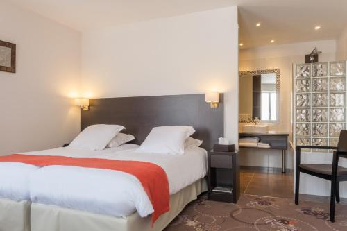 a hotel room with two beds and a bathroom at La Rose in Juliénas