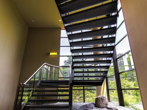 a spiral staircase in a house with a large window at Hakone Kowakien Miyamafurin in Hakone