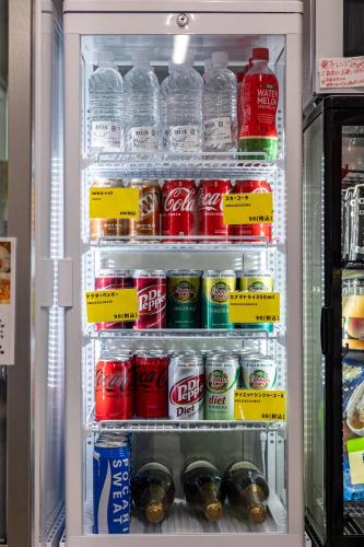 a refrigerator filled with lots of drinks and sodas at ねこ蔵の宿 飛騨 in Hida