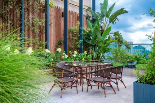 a patio with a table and chairs and plants at Wuyu Hotel - Chongqing Jiangbei Airport & Light Rail in Chongqing