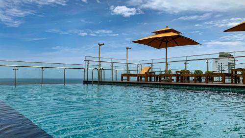 a swimming pool with a table and an umbrella at Sofia Colombo City Hotel in Colombo