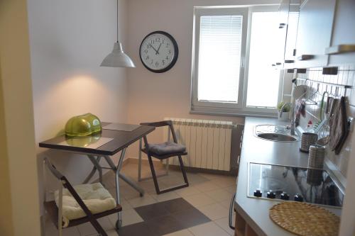 una cucina con tavolo e orologio sul muro di Apartment Danica a Belgrado