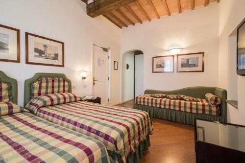 a hotel room with two beds in a room at Hotel Italia in Siena