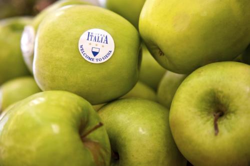 a pile of green apples with a sticker on them at Hotel Italia in Siena