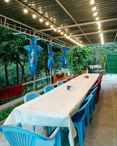 a large long table with blue chairs and lights at Camping Three poplars by VL in Alaverdi