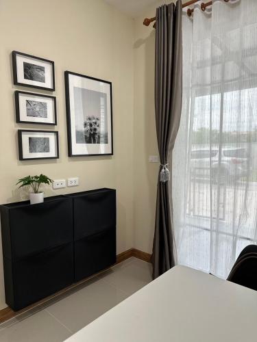 a bedroom with a black dresser and a window at The one CozyHome in Nakhon Ratchasima
