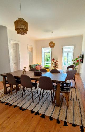 a living room with a wooden table and chairs at Casa do Carril in Aveiro