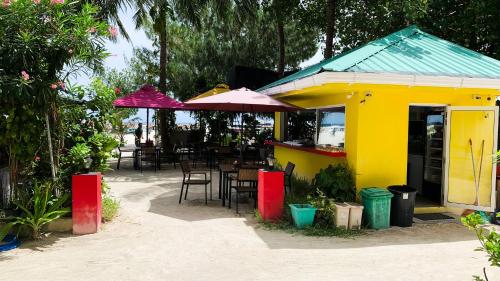 a restaurant with tables and chairs and umbrellas at iCom Marina Sea View in Maafushi