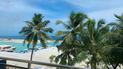 a view of a beach with palm trees and the ocean at iCom Marina Sea View in Maafushi