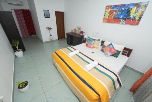 a bedroom with a large bed with pillows on it at VILLA MANTRAA in Varkala