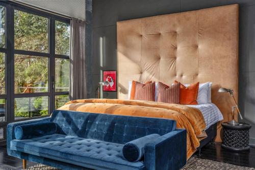 a bedroom with a large bed and a blue couch at Black Star, Kangaroo Valley in Kangaroo Valley