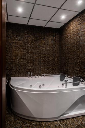 a large white bath tub in a bathroom at ELPIDA Hotel - All Inclusive & Beach Front in Golden Sands