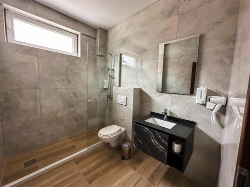 a bathroom with a toilet and a sink and a mirror at Grand Apartments Prishtina in Pristina