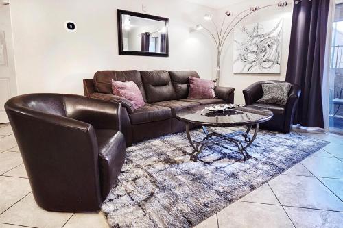 a living room with a leather couch and a table at UPGRADED & STYLISH, POOL, HOT TUB, WALK TO STRIP! in Las Vegas