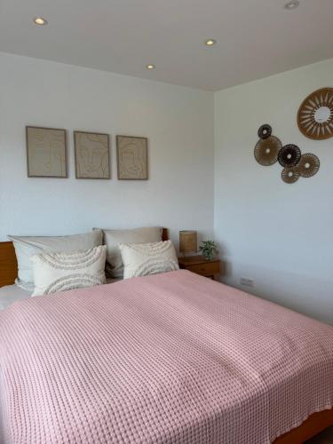 a bedroom with a large bed with a pink blanket at Cozy Apartment Wolke in Wuppertal