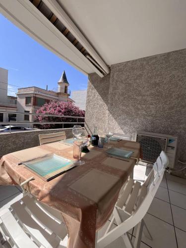 une table et des chaises sur un balcon avec vue sur un immeuble dans l'établissement Appartement T3 spacieux proche plage climatisation - 6PELI4, à Canet