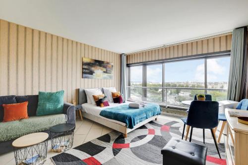 un salon avec un canapé et une grande fenêtre dans l'établissement Seine & Eiffel Flat AC, à Paris