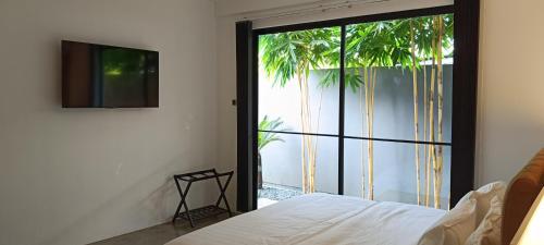 a bedroom with a bed and a sliding glass door at 928 Caxa Juan in Dipolog
