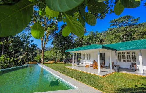 a house with a swimming pool in front of it at Spring Villa Neluwa in Nelluwa