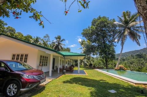 a car parked in front of a house with a swimming pool at Spring Villa Neluwa in Nelluwa