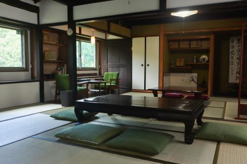 a living room with a table and green chairs at みずまの宿 - Mizuma no yado in Kubo