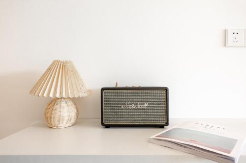 a small radio sitting on a table next to a lamp at Huangshan Taiping Lake Muxin Hotel in Fenghuangshan