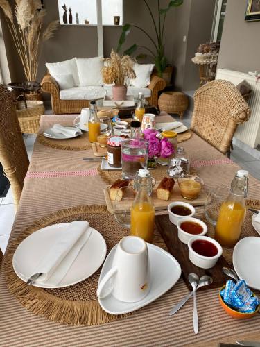a table with plates of food and drinks on it at Séverine chambres d’hôtes in Floing