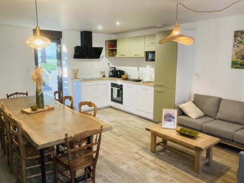 une cuisine et un salon avec une table et un canapé dans l'établissement Le domaine des figuiers - Gîte des pèlerins, à Servon