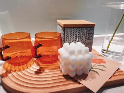 a wooden tray with two glasses and a bowl of grapes at Huangshan Taiping Lake Muxin Hotel in Fenghuangshan