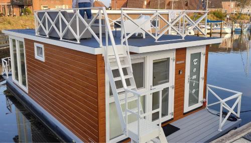 a small house on a boat in the water at Houseboat Tomio near Amsterdam in Monnickendam