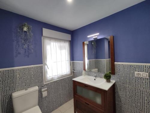 a bathroom with a sink and a toilet and a window at Apartamento céntrico con Wifi Avilés in Avilés