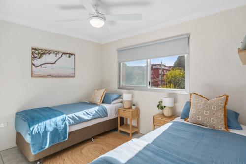 une chambre avec deux lits et une fenêtre dans l'établissement North Beach Escape - Balcony Sunrises and Ocean Walks, à Wollongong