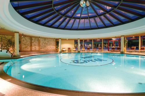 a large swimming pool with a glass ceiling at Hotel Tyrol am Haldensee in Haldensee