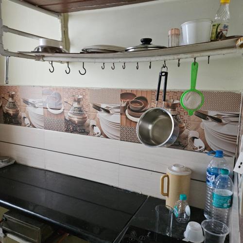 a kitchen with pots and pans on a shelf at 2BHK House in Kushālnagar