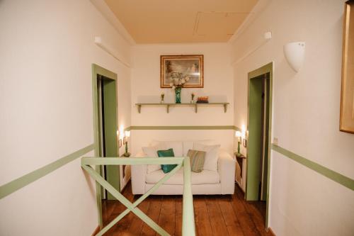 a living room with a white couch and two windows at Prosecco Collalto Lodge in Susegana