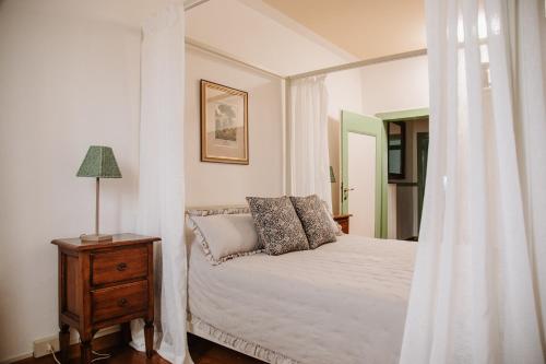a bedroom with a white bed with a nightstand and a window at Prosecco Collalto Lodge in Susegana