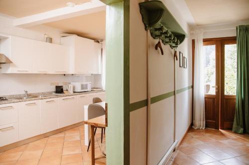 a kitchen with white cabinets and a green stripe on the wall at Prosecco Collalto Lodge in Susegana