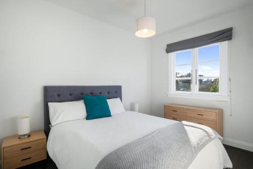a bedroom with a large bed and a window at Ocean Breeze - Foxton Beach Holiday Home in Foxton