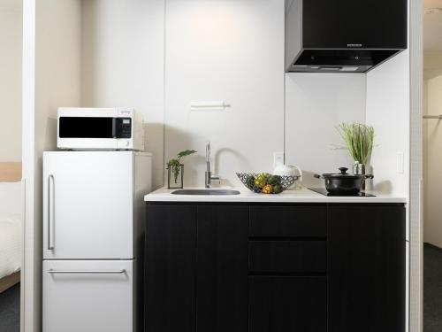 a kitchen with a white refrigerator and a sink at MIMARU Osaka Shinsaibashi East in Osaka