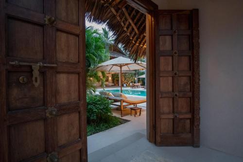 an open door leading to a patio with a pool at Palm Garden ECO Boutique Hotel No Kids under 12 in Watamu