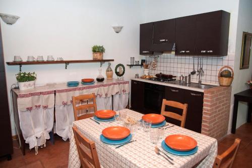 a kitchen with a table with orange plates on it at Tenuta Colle Mattia in Colonna