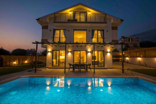 a villa with a swimming pool at night at Villa Bahar 3 Oludeniz Luxury Villa in Fethiye
