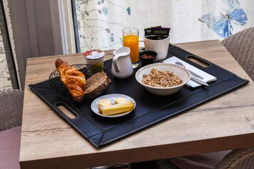 een dienblad met ontbijtproducten op tafel bij Hotel K'Loys in Paimpol