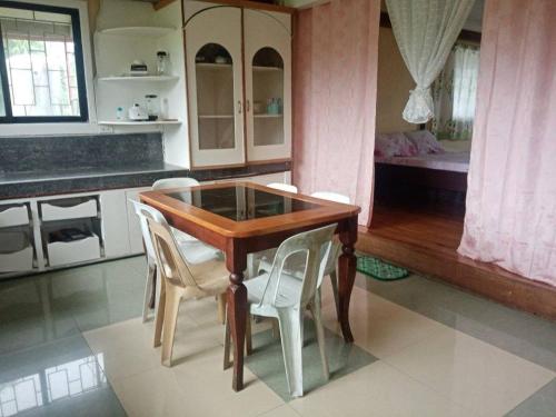 a kitchen with a wooden table and white chairs at Davao City-Marilog Peak Cafe- Traveler's Staycation in Davao City