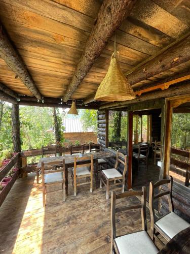 a wooden deck with chairs and tables and a ceiling at Shtepizat e Rames Agroturizem in Librazhd